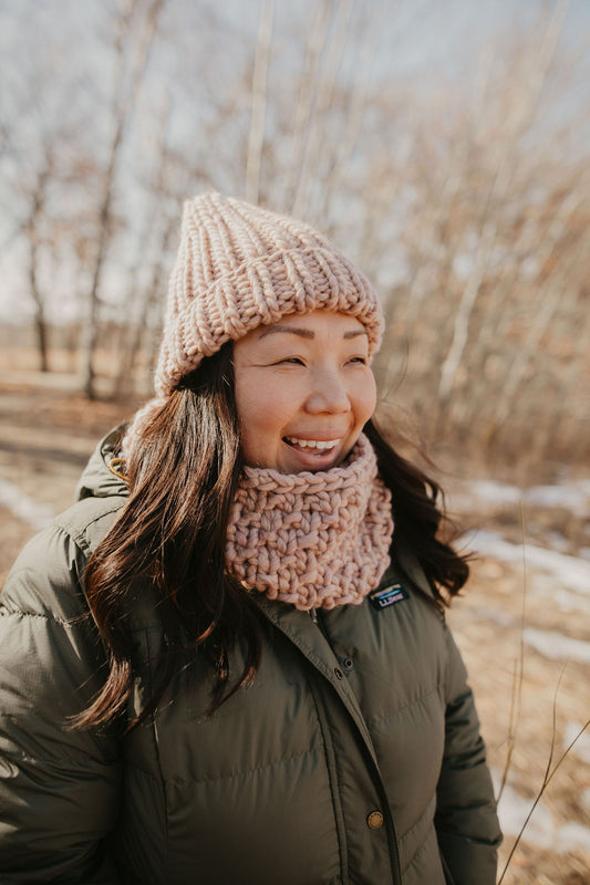 Model wearing blush pink hand knit cowl and hat