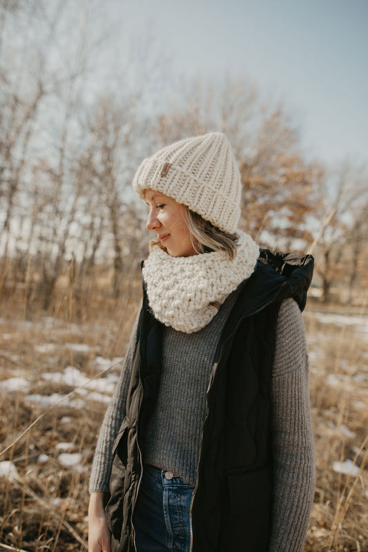 Model wearing chunky knit ivory cowl and hat
