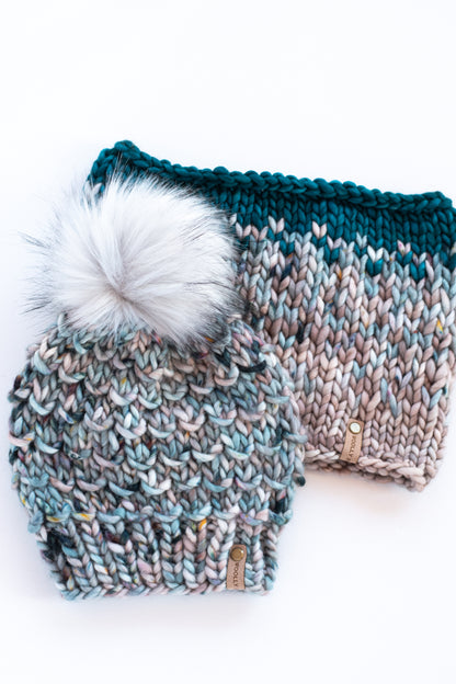 Blue speckled merino wool knitted hat and fair isle cowl on a white background