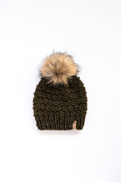 Olive green knitted beanie with a fur pom-pom on a white background