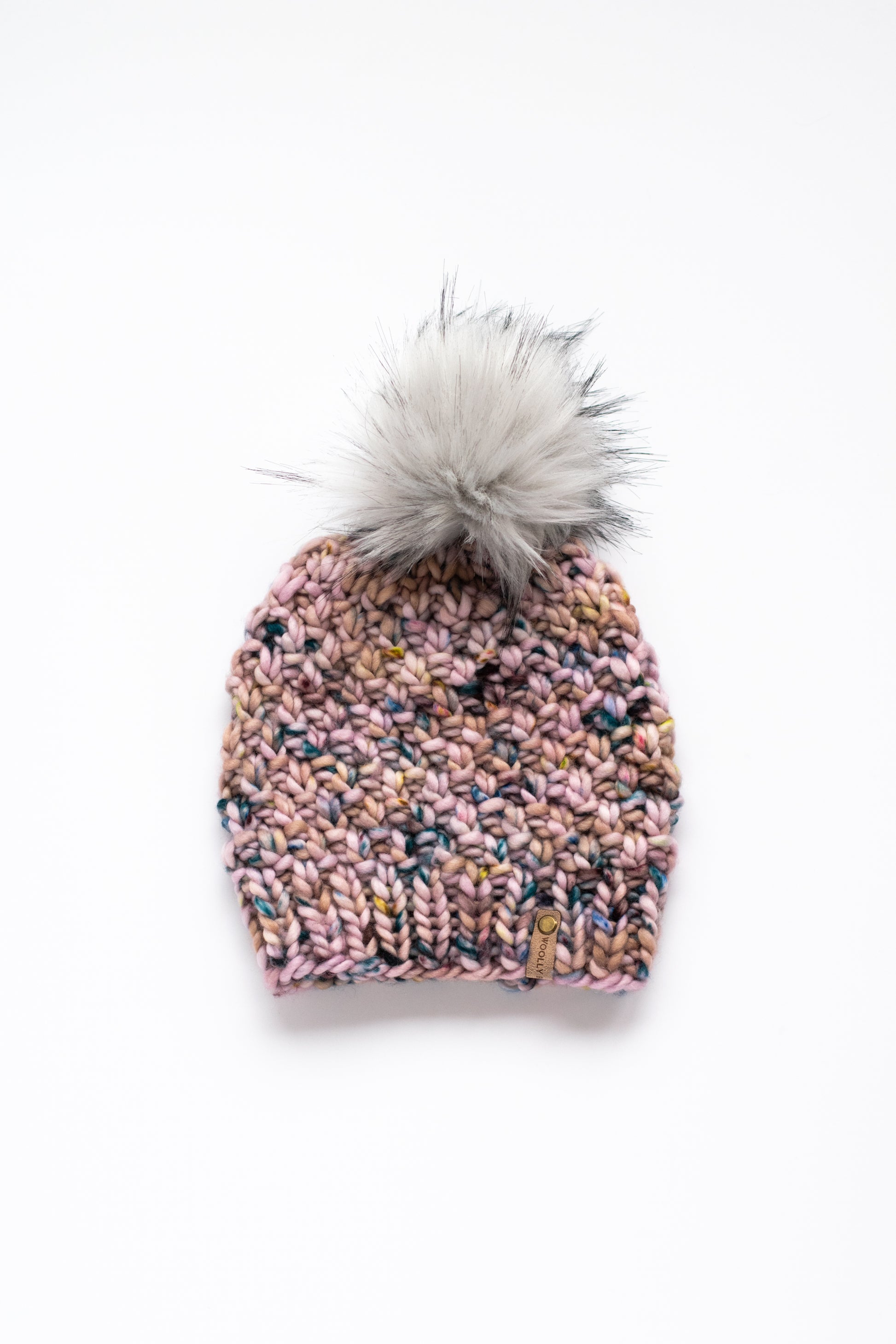 Pink knit beanie with a gray pom-pom on a white background
