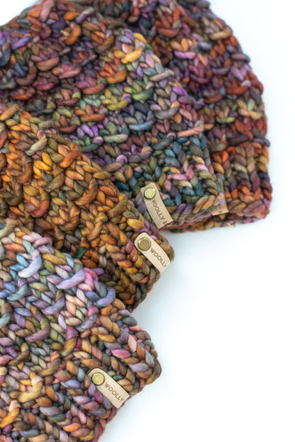 A stack of brown colorful knitted hats on a white background.