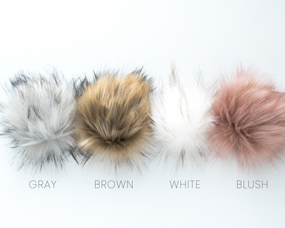 Four fluffy pom-poms in gray, brown, white, and blush colors on a light background.