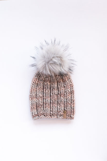 Gray ribbed knit hat with a fluffy gray pom pom on a white background
