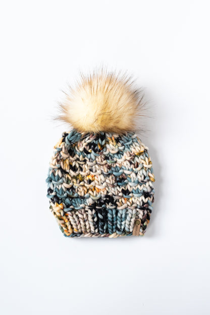 colorful knitted beanie with a pom-pom on a white background