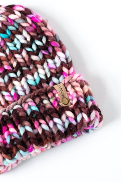 Multicolored knitted hat with a brand logo on a white background