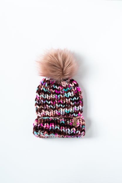Multicolored knit beanie with a pom-pom on a white background