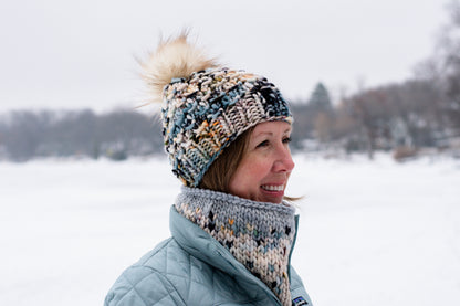 Woman wearing a knitted hat and scarf in a snowy landscape