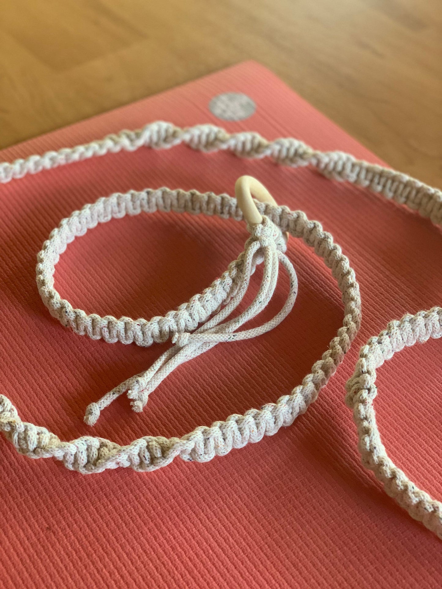 Macrame yoga mat strap that I made and created. :) the wooden ring folds  back on itself and you pull the cord through to create a loop for the mat  to slide