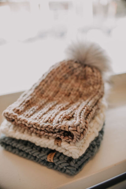 Stack of three knitted hats on a table